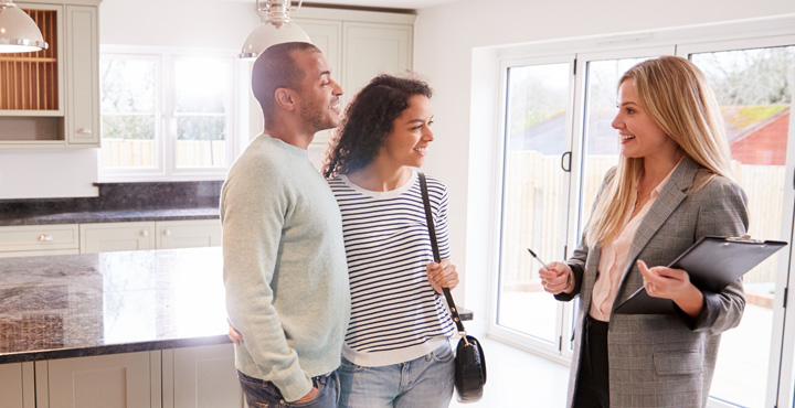 Photo of couple chatting to real estate agent